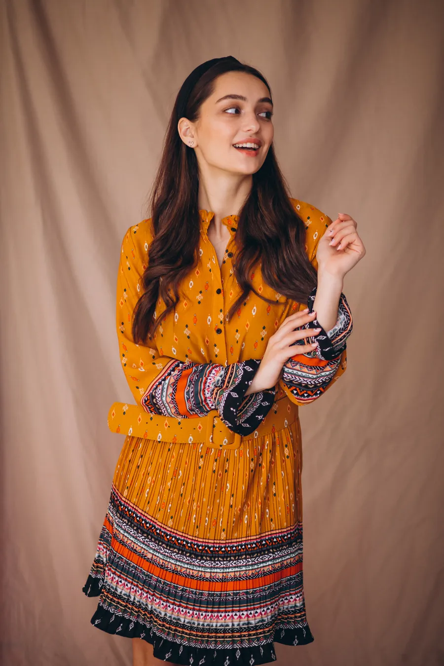 Mustard yellow printed dress with patterned cuffs and a pleated hem